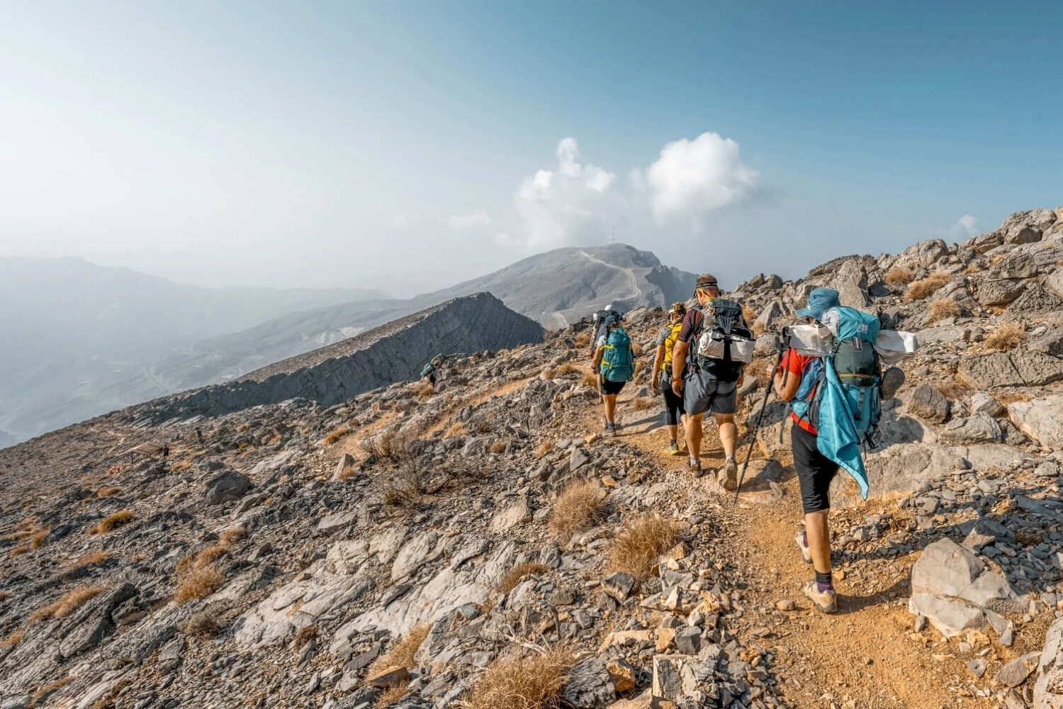 Hikers crossing a high ridge on Jebel Jais